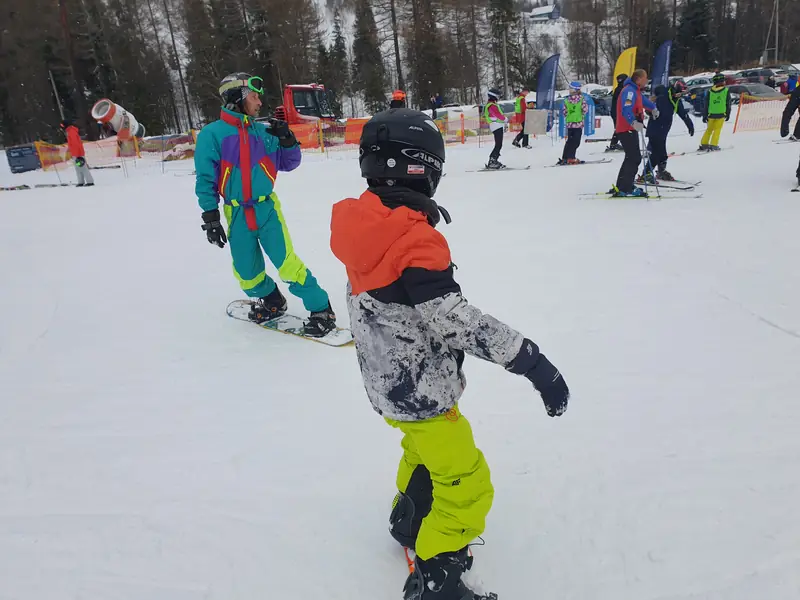 Młody snowboardzista na stoku podczas obozu zimowego
