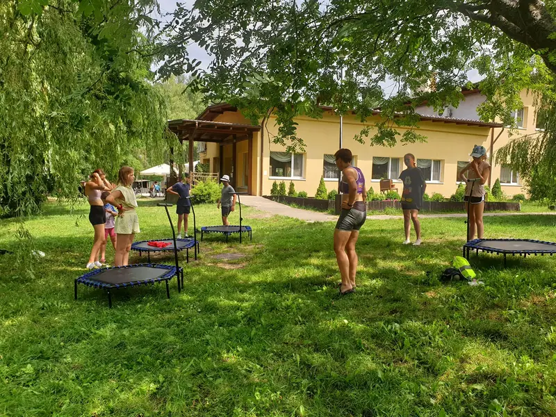 Zajęcia na trampolinach fitness na trawie przed ośrodkiem